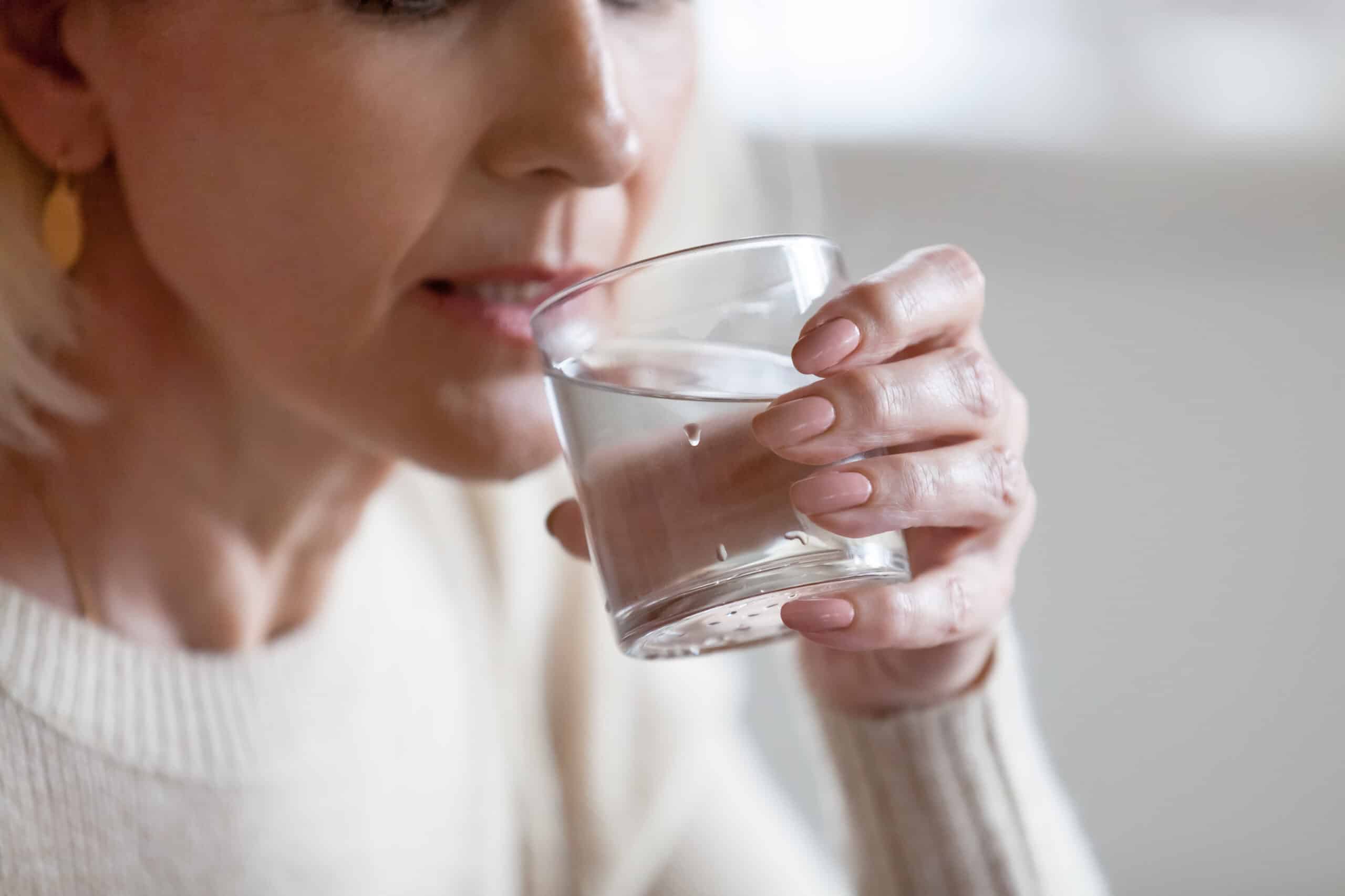 Woman sipping water from a glass.