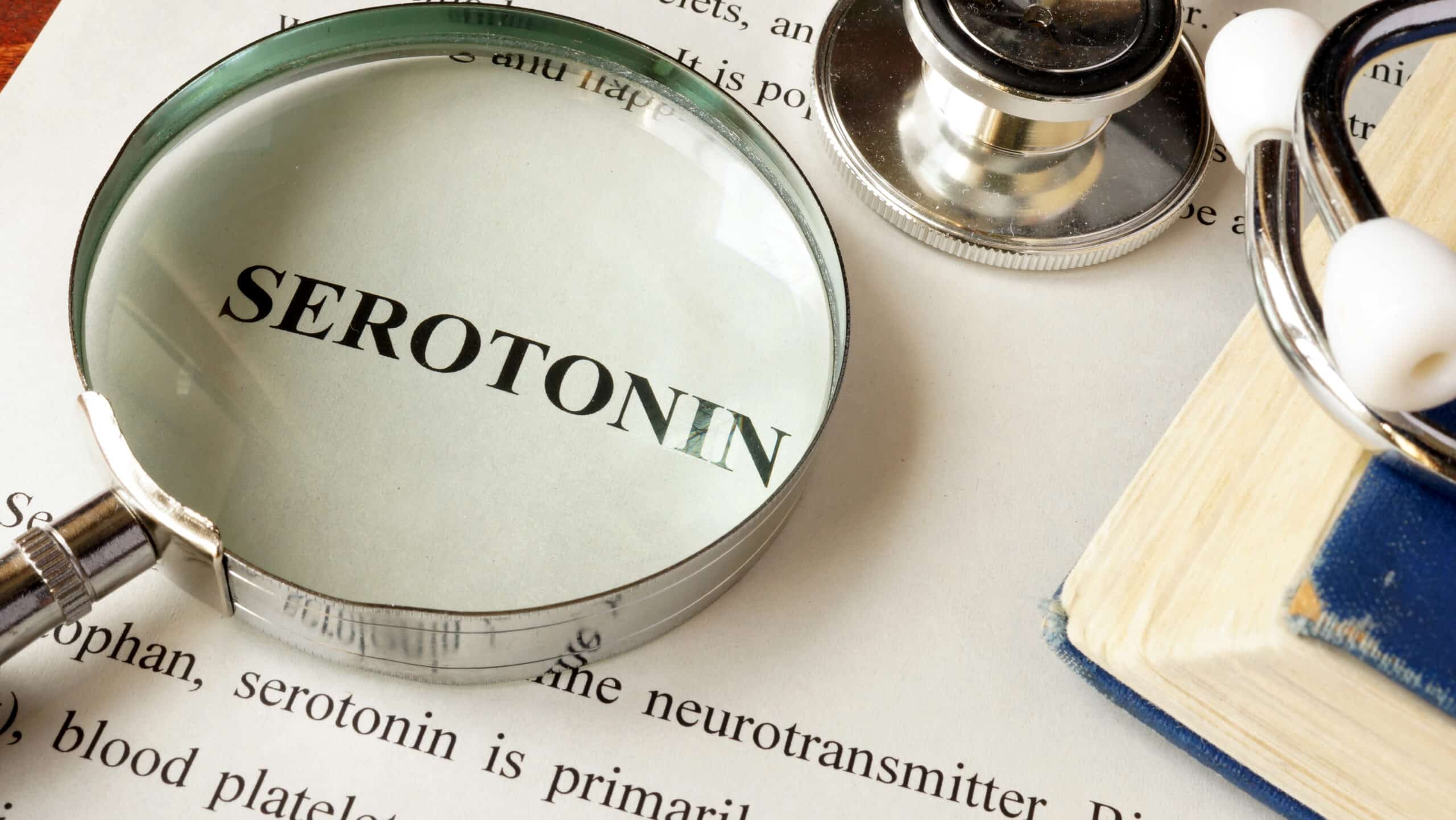 Serotonin – dictionary image with magnifying glass.