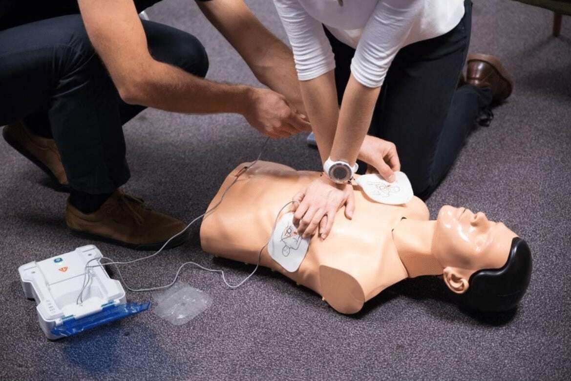 Rescuers place AED pads on patient’s chest.