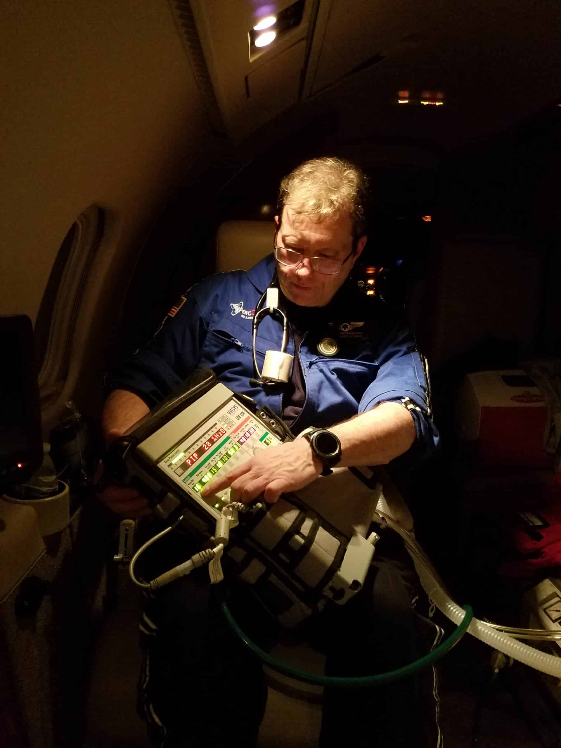 Adjusting patient ventilator during flight.