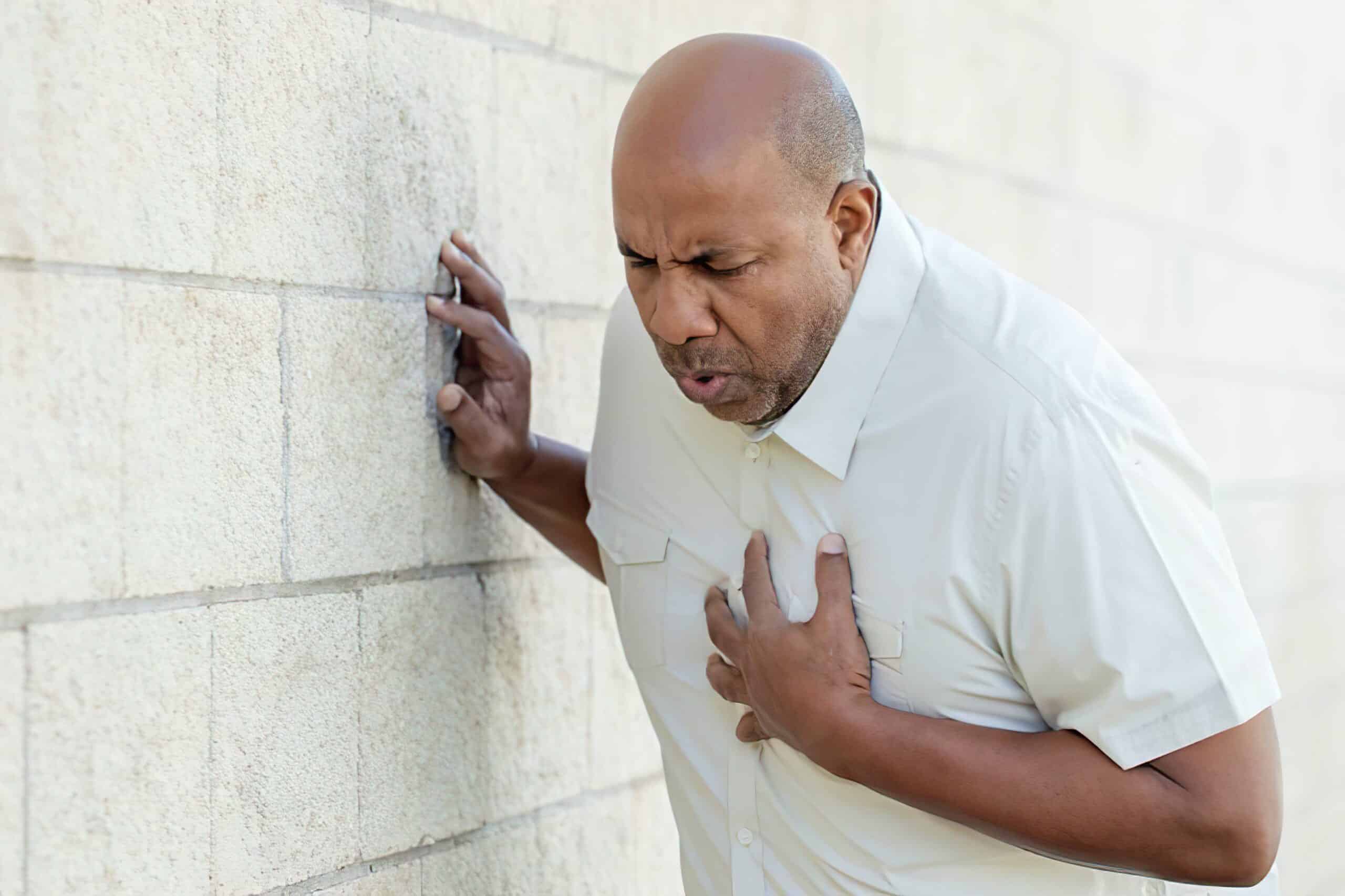 Patient clutches chest, potential sign of acute coronary syndrome.