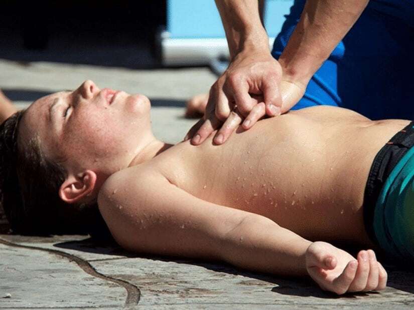 Rescuer performs child CPR.