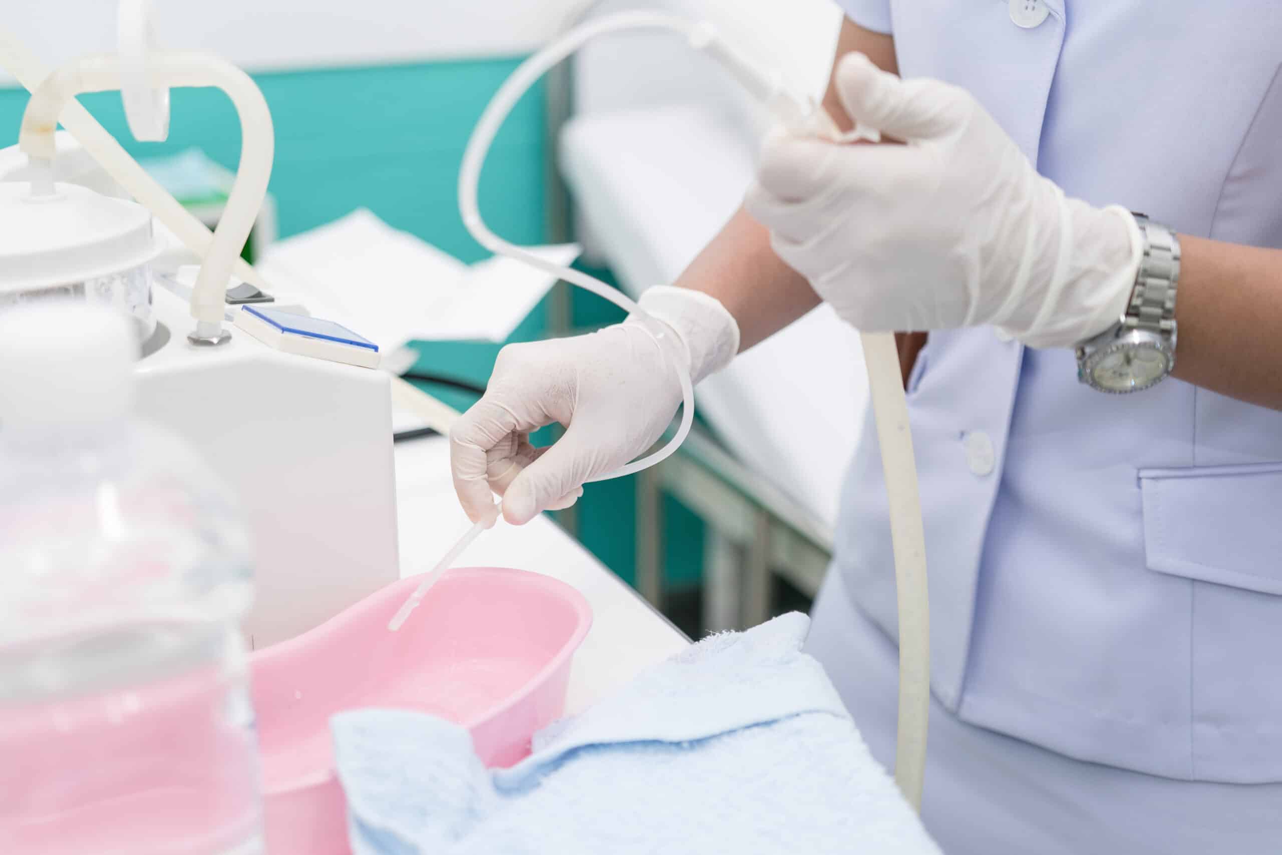 A nurse preparing a suction machine.