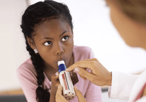 Child using peak flow meter.