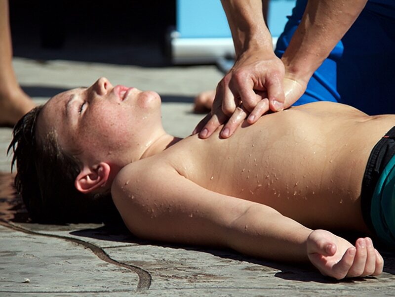 Rescuer performs child CPR.