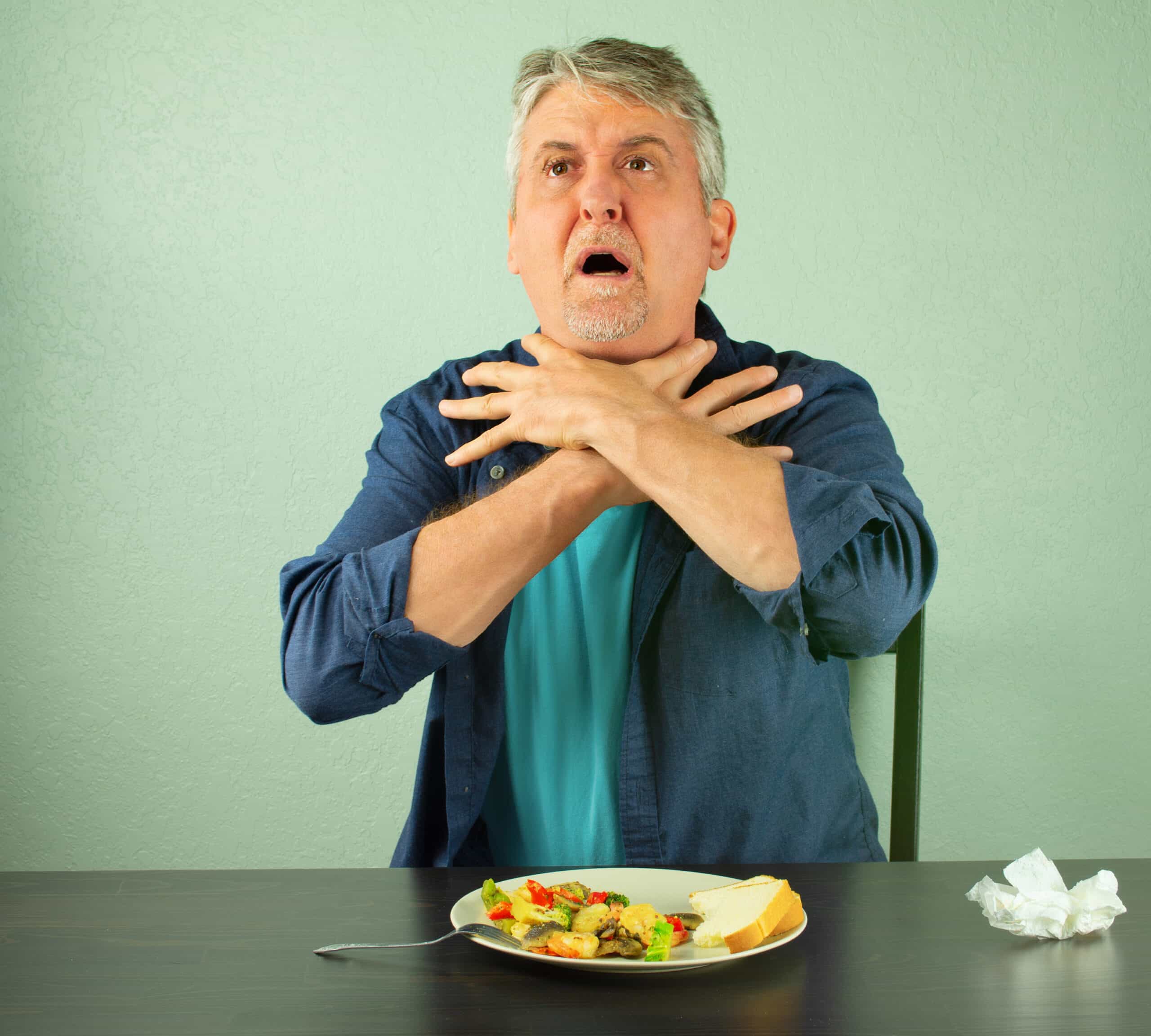 Clutched hands around throat is universal choking sign.