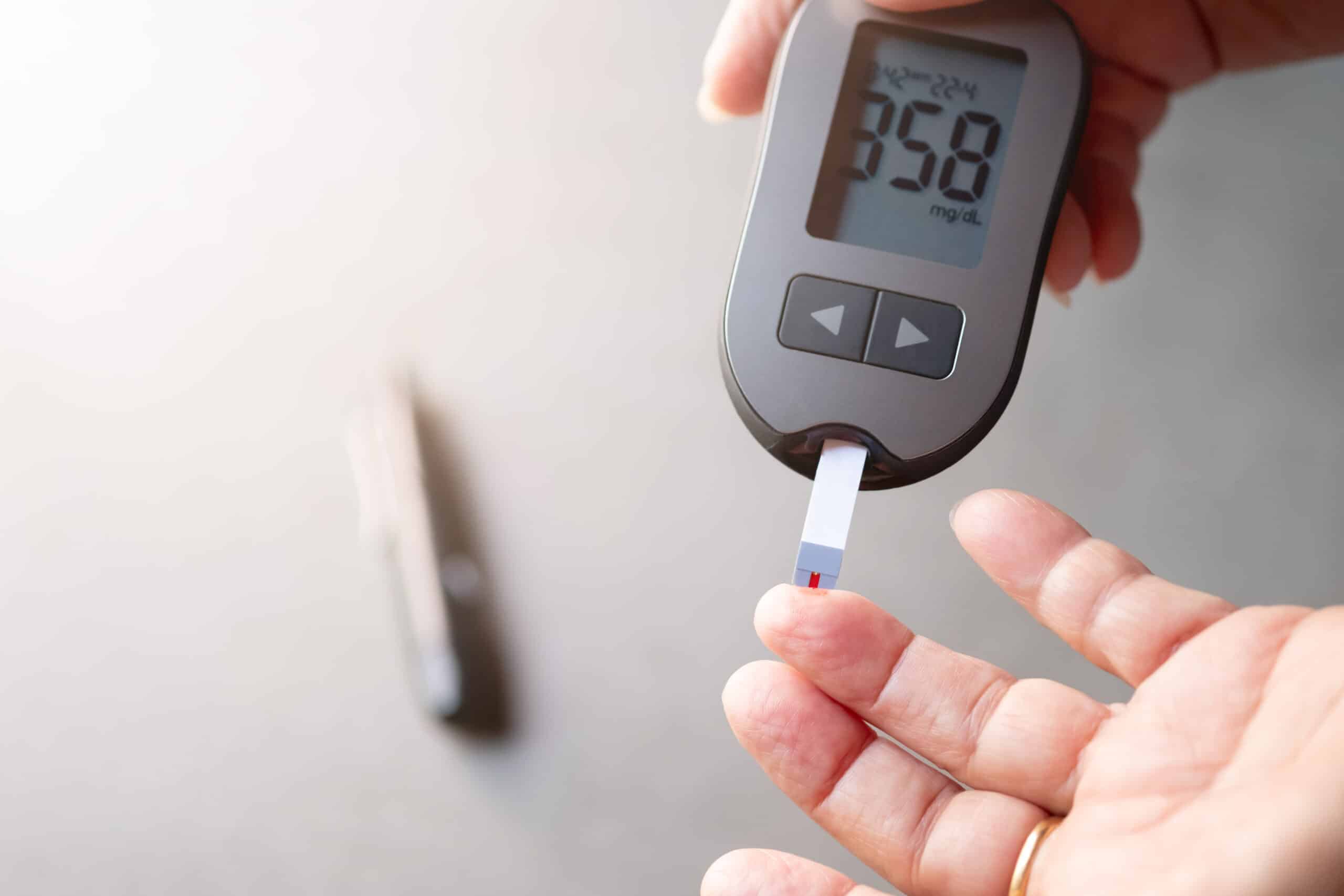 Hyperglycemia - person testing blood sugar with a finger prick.